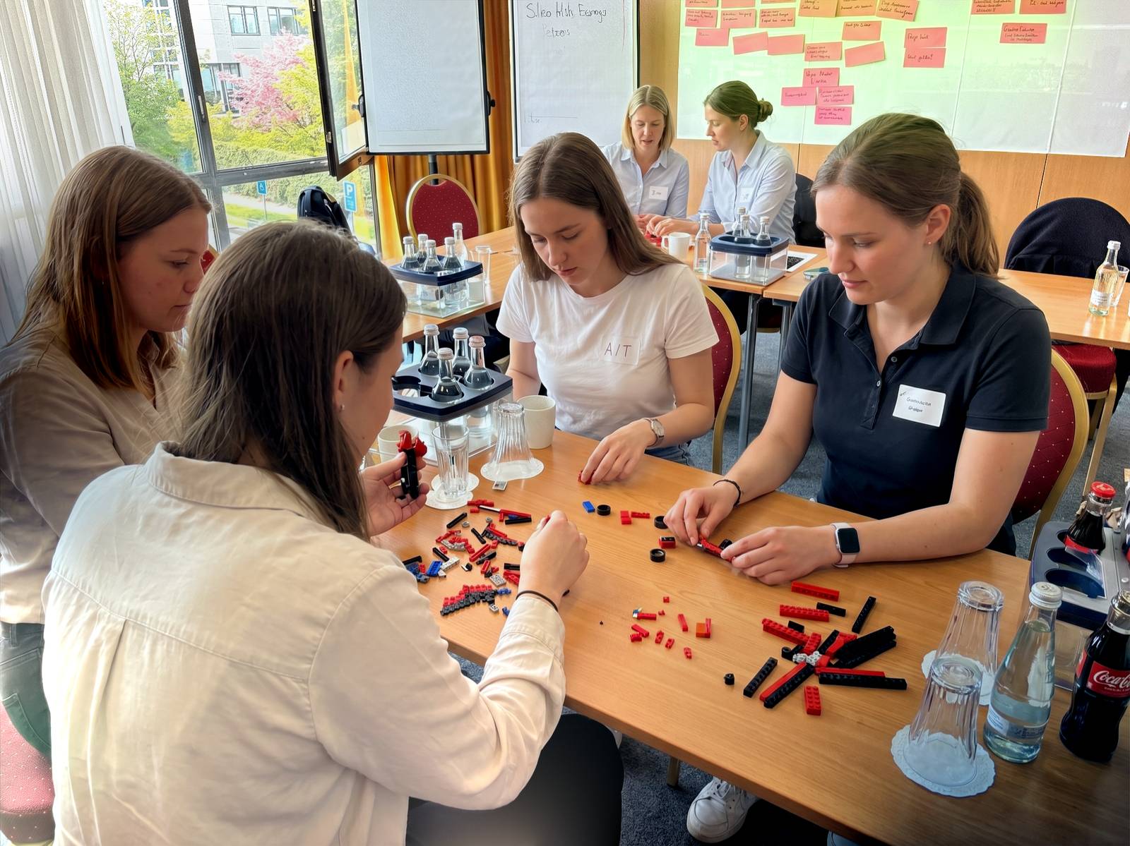 Team baut konzentriert an einem Tisch mit Klemmbausteinen